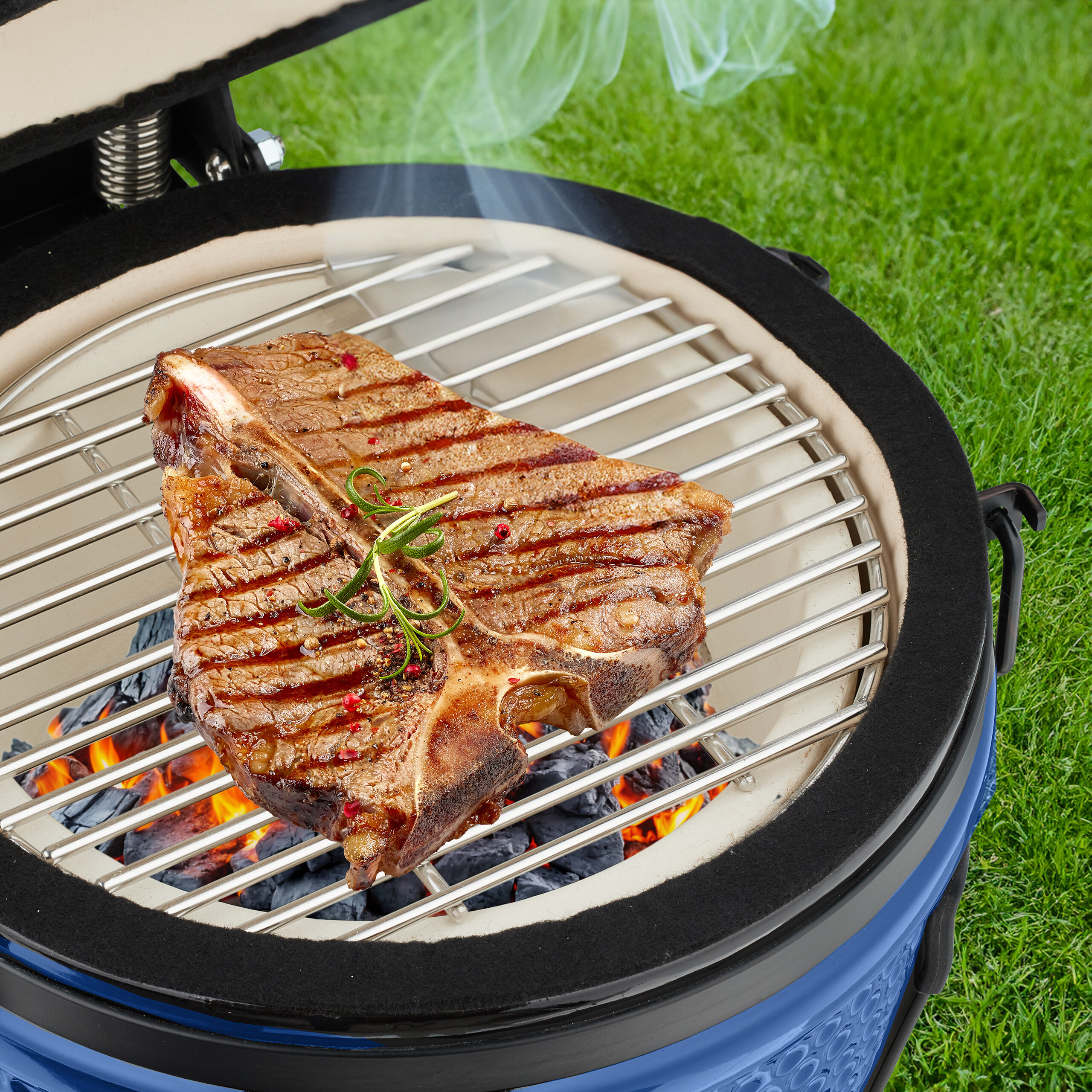 Ein saftiges T-Bone-Steak mit Kräutern auf einem Holzkohlegrill mit aufsteigendem Rauch.