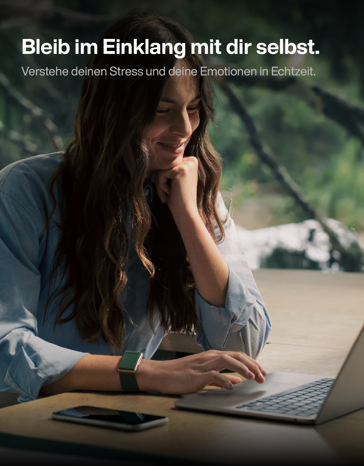 Eine Frau in einem blauen Hemd sitzt vor einem Laptop in der Natur, mit Text darüber.