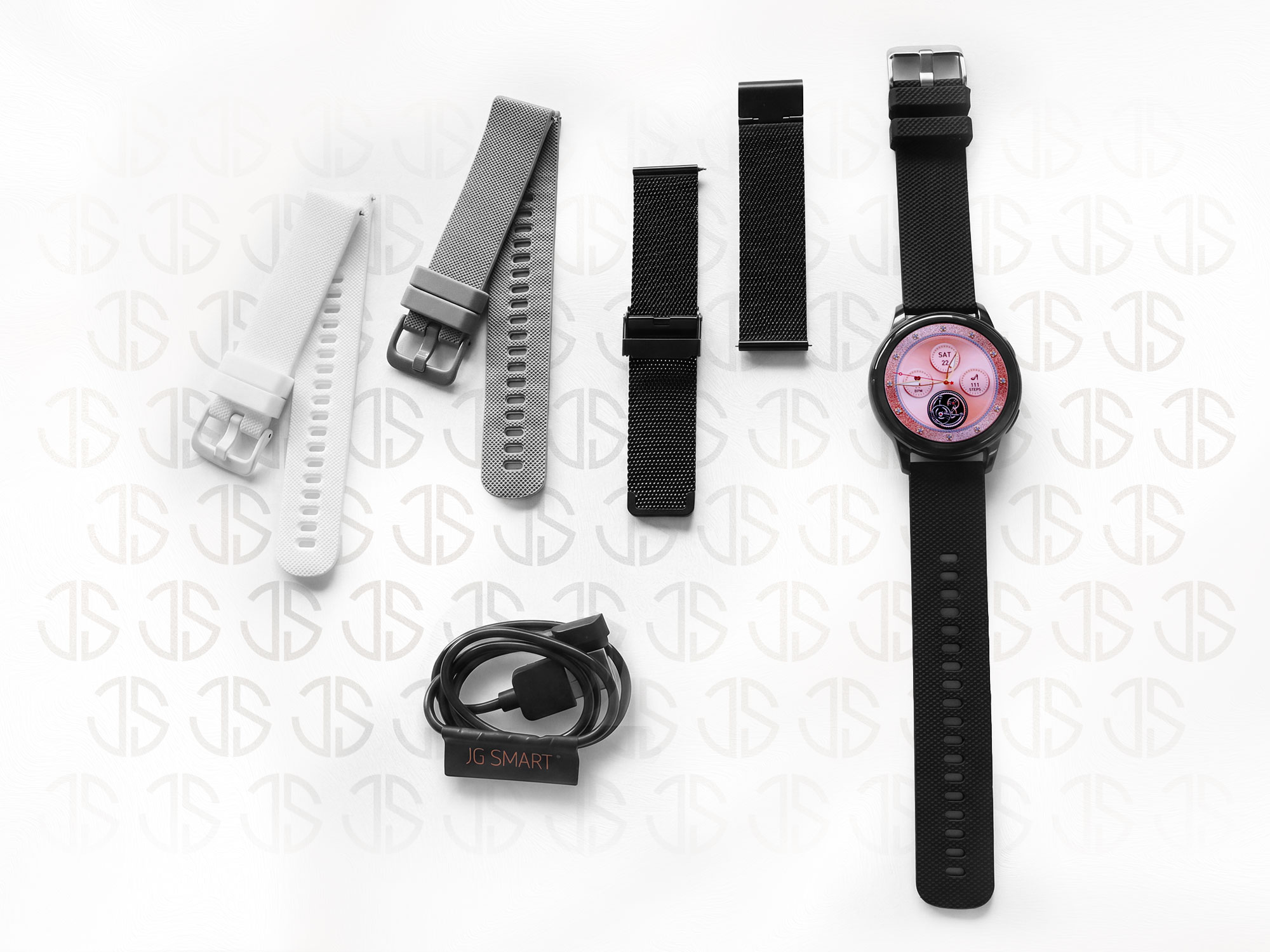 Czarny smartwatch z kilkoma wymiennymi paskami w kolorze białym, szarym i czarnym oraz kablem ładującym.