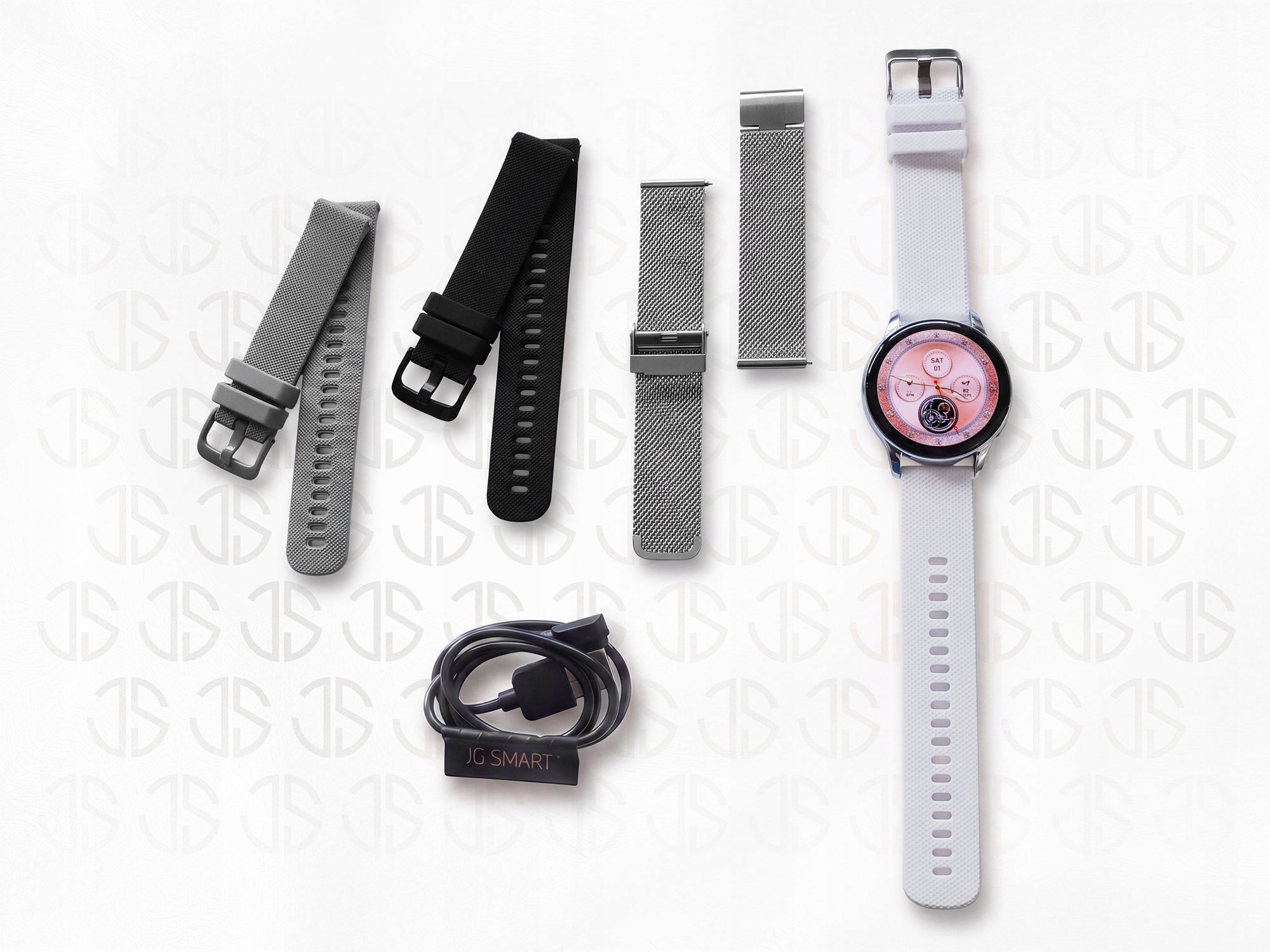 Smartwatch z białym paskiem, trzema dodatkowymi paskami i kablem ładującym na jasnym tle.