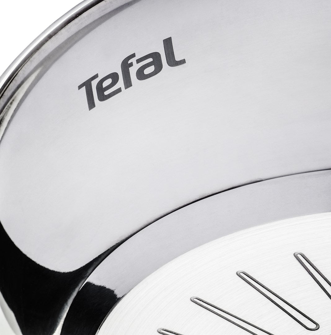 Zbliżenie srebrnego garnka Tefal z widocznym logo.