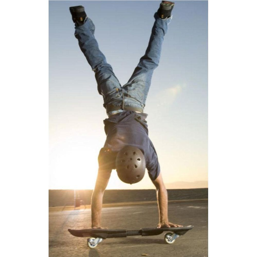 Skater robi stanie na rękach na swojej dwukołowej desce podczas zachodu słońca.