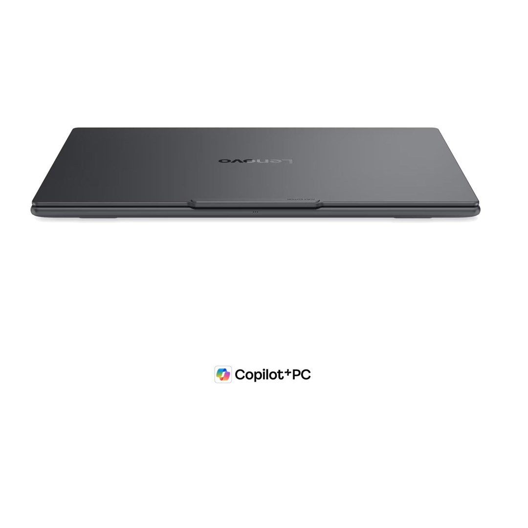Zamknięty szary laptop Lenovo na białym tle z logo Copilot+PC.