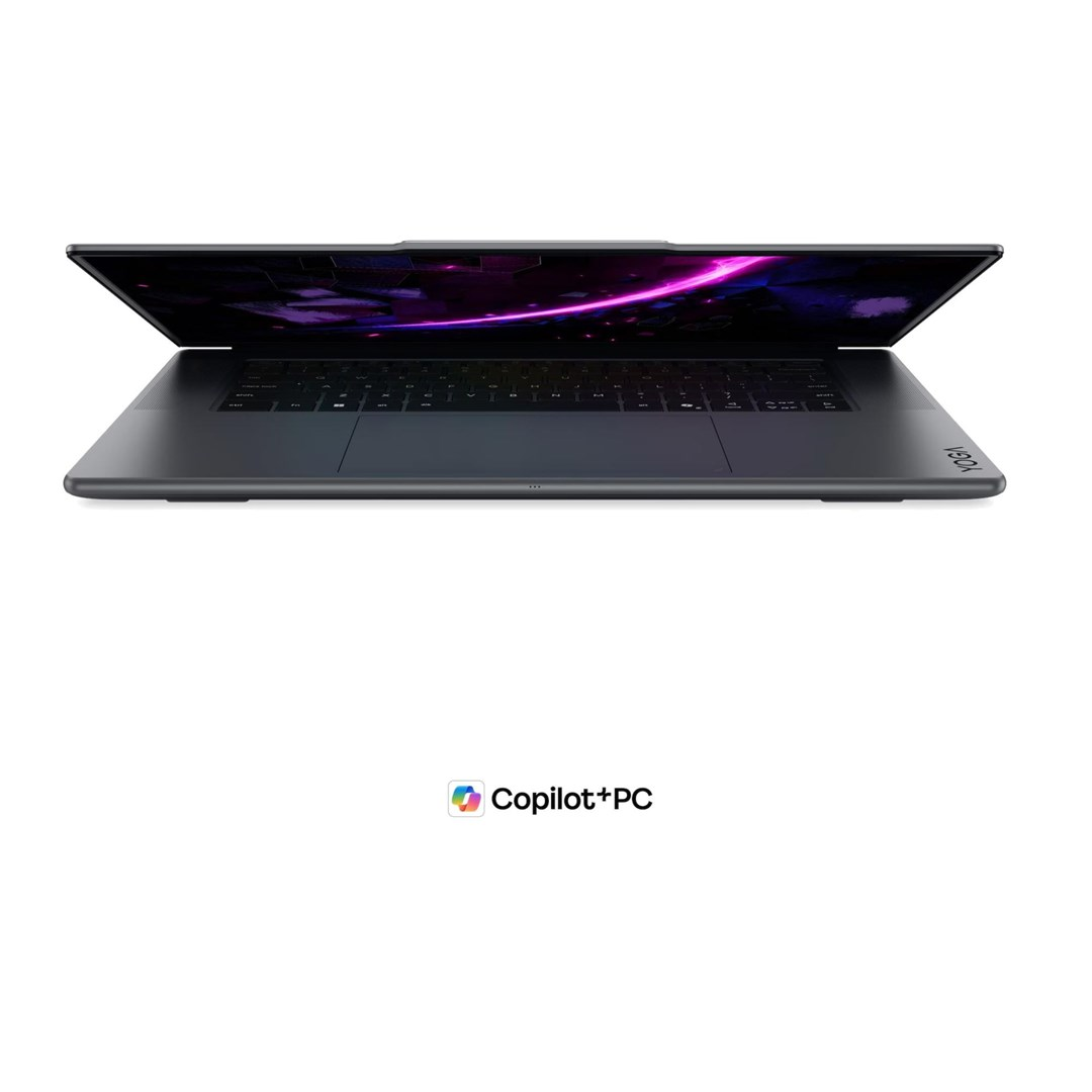 Ciemnoszary laptop Lenovo Yoga widziany z przodu, z fioletową tapetą i logo Copilot+PC.