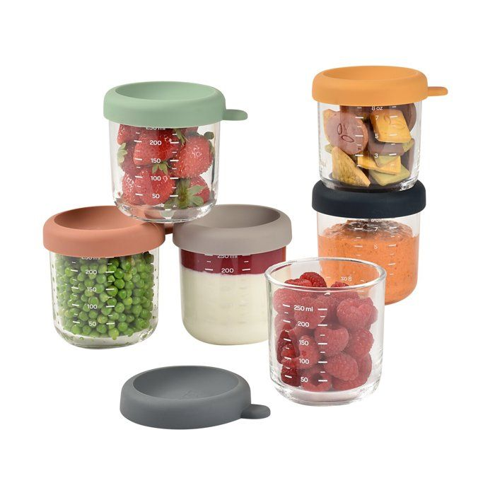 Glasbehälter mit bunten Silikondeckeln gefüllt mit Erdbeeren, Erbsen, Joghurt, Crackern und Himbeeren.