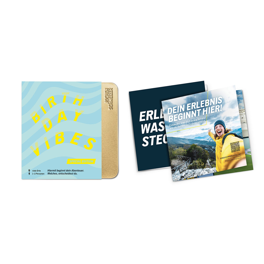 Geschenkbox mit blauem Umschlag und gelben Buchstaben mit der Aufschrift BIRTHDAY VIBES, daneben offene Karten.
