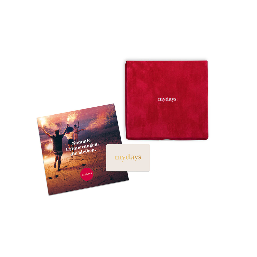 Rote MySays Geschenkbox, eine Gutscheinkarte und eine Karte mit drei Menschen am Strand mit Wunderkerzen.