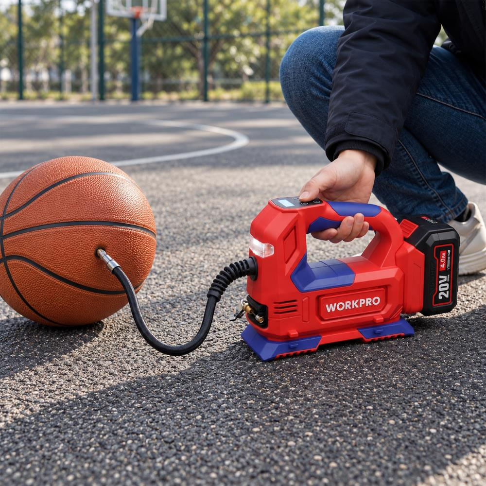 Bir kişi sahada bir basketbol topunu şişirmek için kırmızı kablosuz hava pompası kullanıyor.