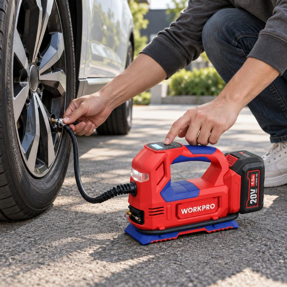 Bir kişi, araba lastiğini şişirmek için kırmızı ve mavi kablosuz WORKPRO hava pompasını kullanıyor.