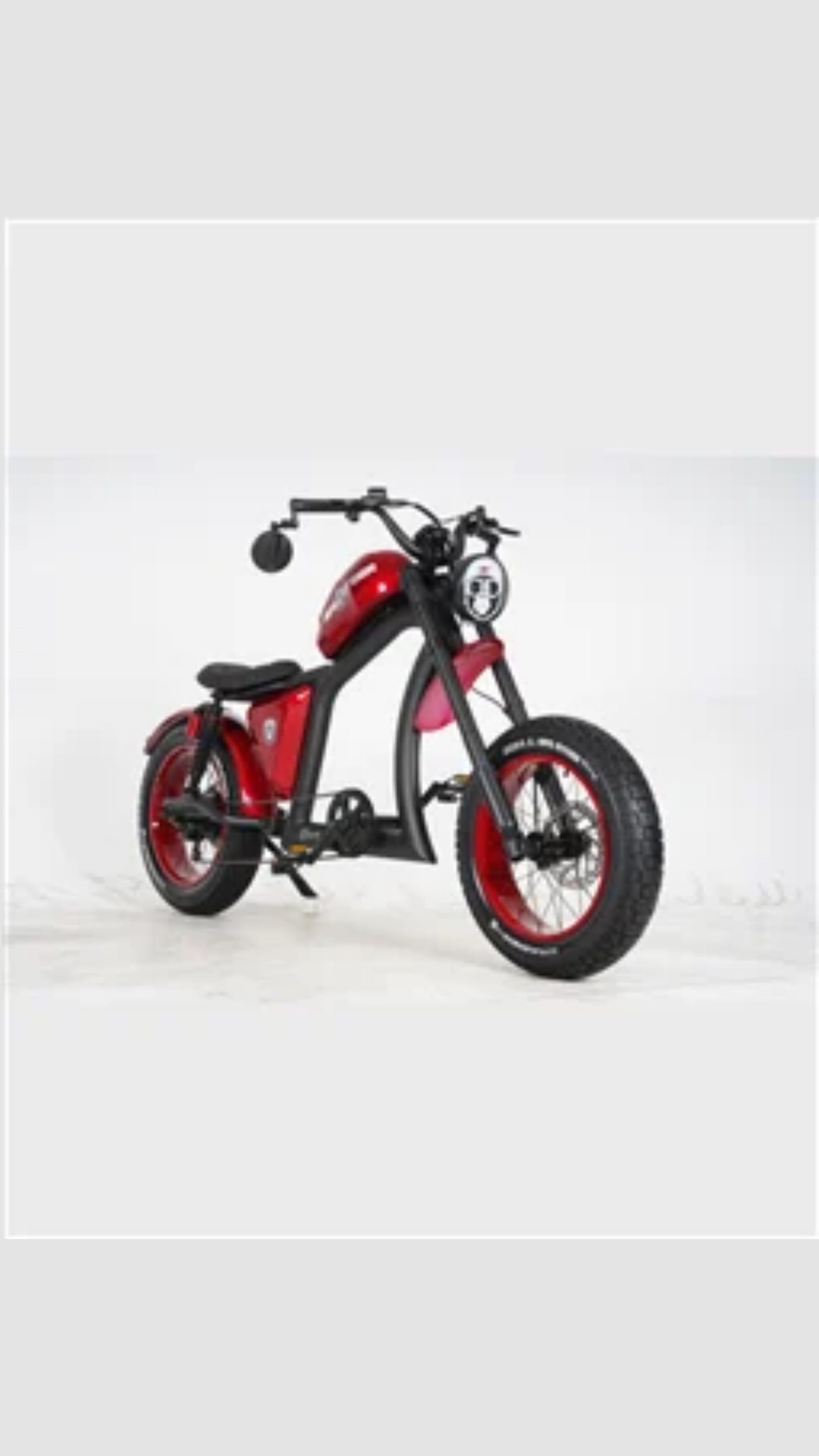 Beyaz arka planda kalın lastikli kırmızı bir chopper tarzı elektrikli motosiklet.