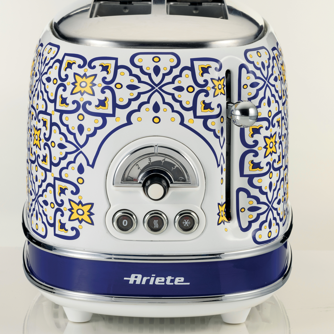 Ein weißer Toaster mit blau-gelbem Majolika-Muster, Chromakzenten und dem Ariete-Logo auf blauem Grund.