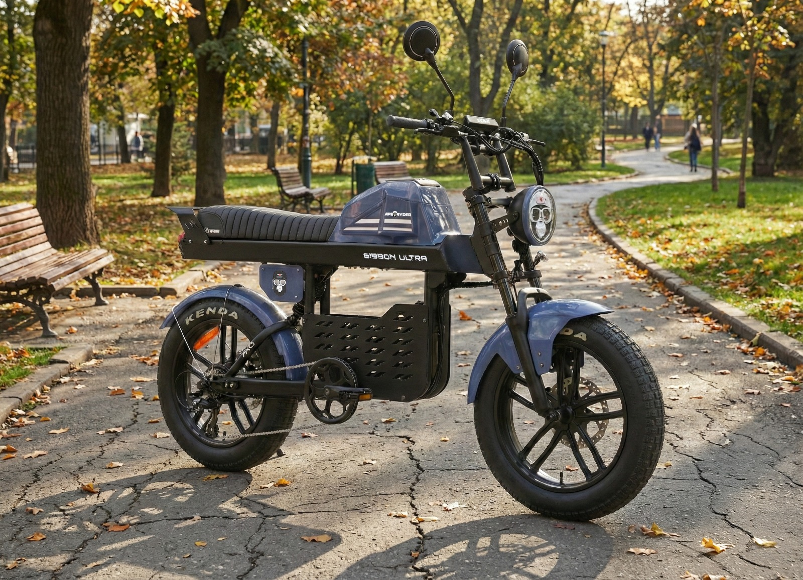 Sonbahar parkındaki asfalt bir yolda park etmiş mavi bir elektrikli moped.