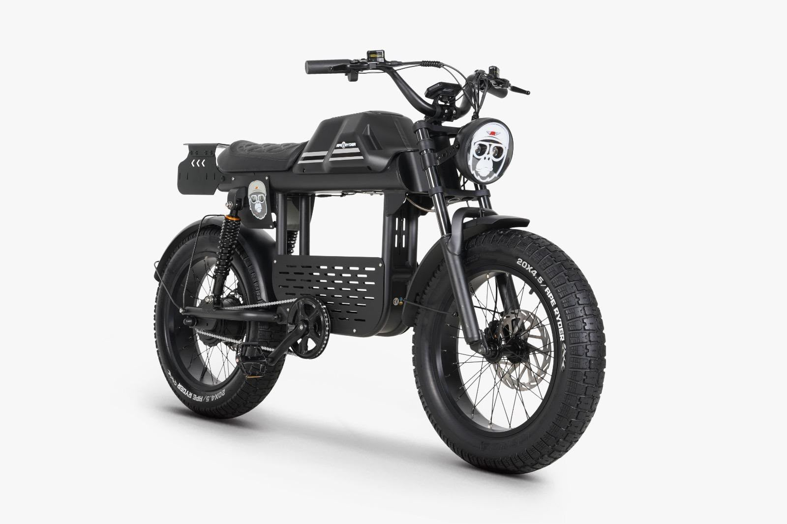 Kalın lastikli, yüksek gidonlu ve farında maymun çıkartması olan siyah elektrikli moped tarzı bisiklet.