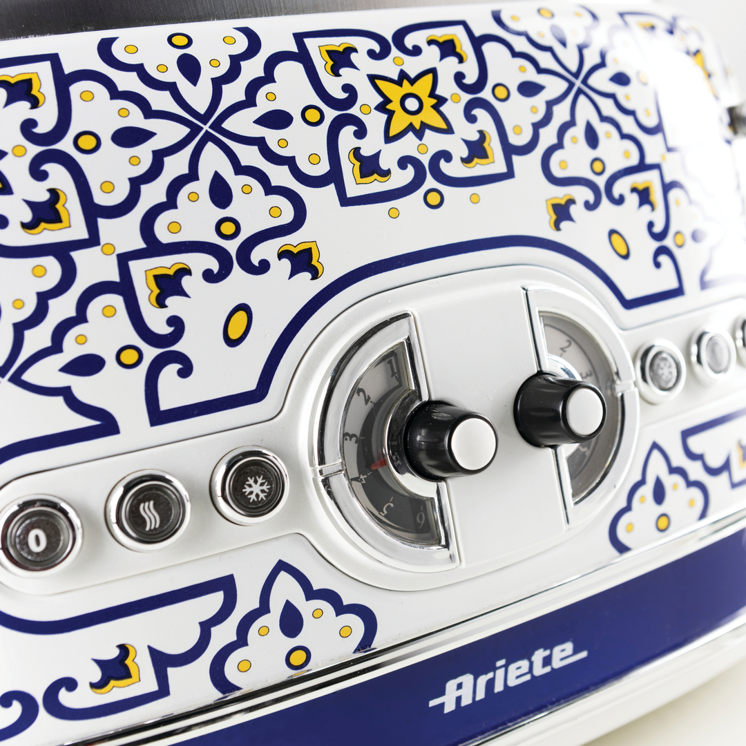 Ein weißer Ariete Toaster mit blau-gelbem Majolika-Muster, Knöpfen und analogen Reglern.