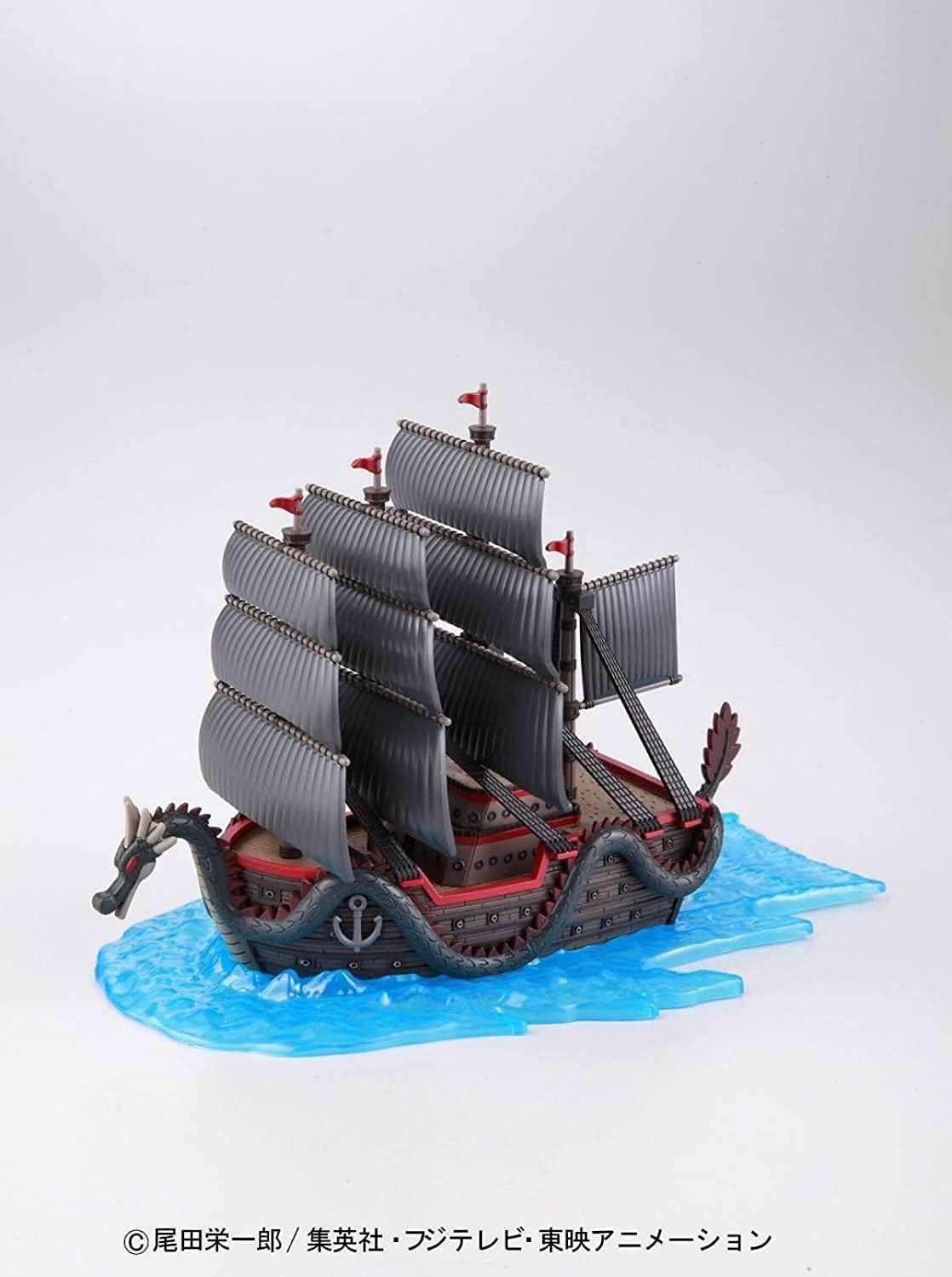 Ein detailliertes Modell eines dunklen Piratenschiffs mit grauen Segeln und Drachengalionsfigur auf blauem Wasser.