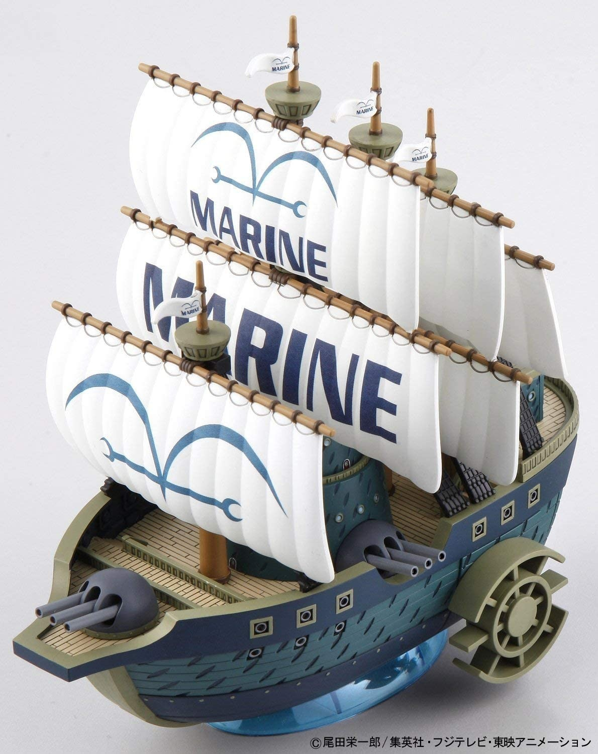 Modell eines Marine-Schiffs mit weißen Segeln und Kanonen auf hellem Hintergrund.