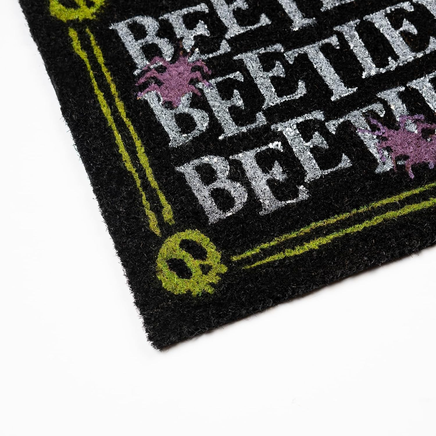 Felpudo negro con texto Beetle blanco, arañas moradas y calaveras verdes.