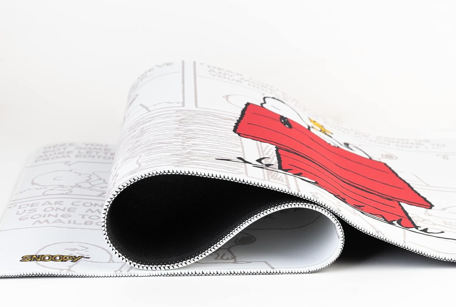 Ein zusammengerolltes Snoopy-Mauspad mit Comic-Design auf weißem Hintergrund.