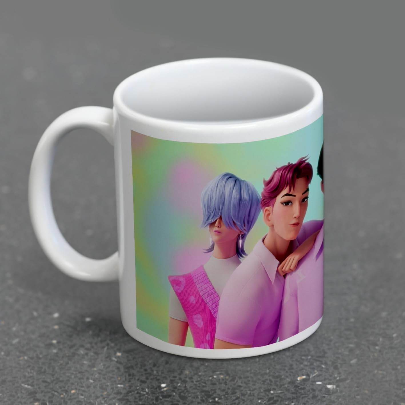 Una taza de café blanca con una ilustración de tres personajes animados sobre una superficie gris.