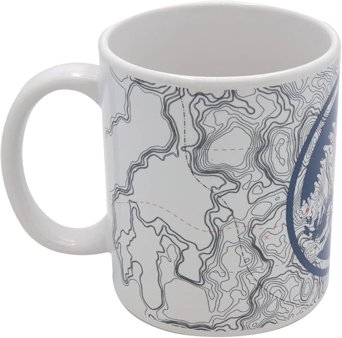 Una taza de cerámica blanca con un diseño de mapa topográfico negro y detalles azules sobre fondo liso.
