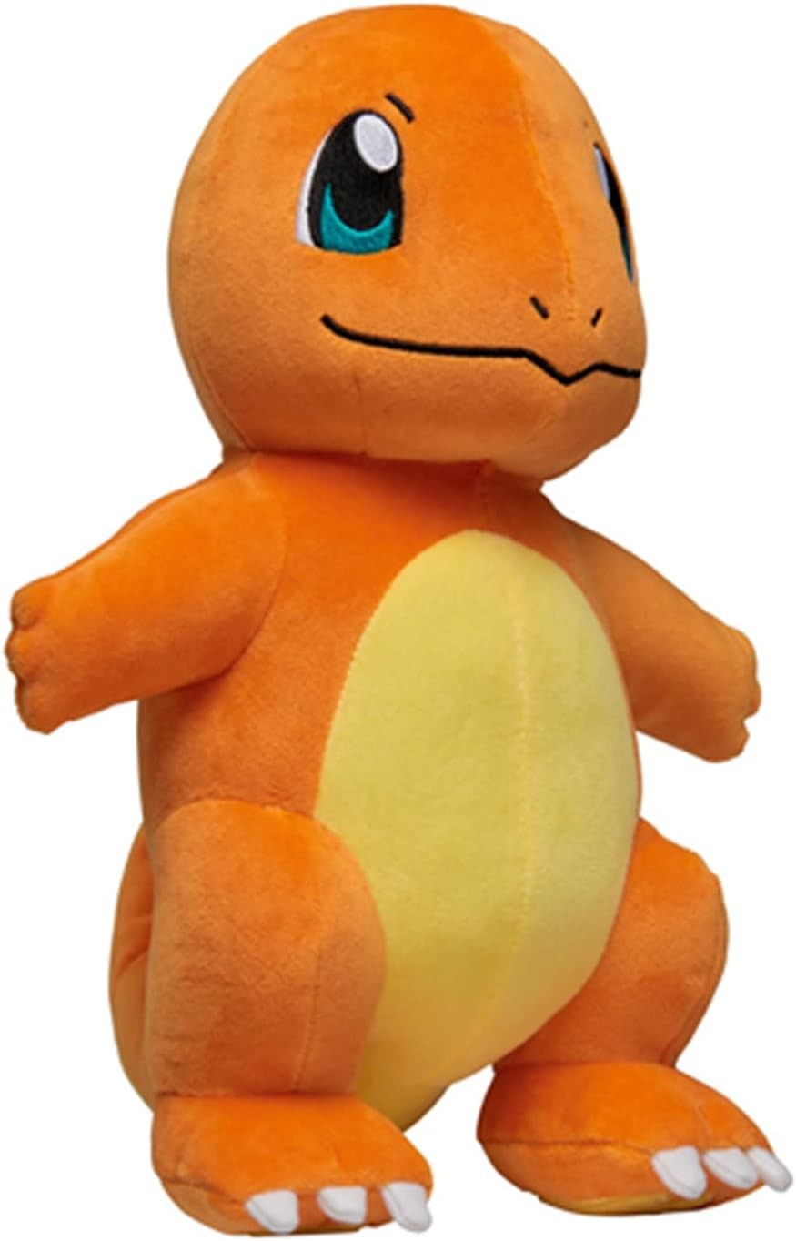 Un peluche naranja de Charmander con vientre amarillo y grandes ojos azules sobre fondo blanco.