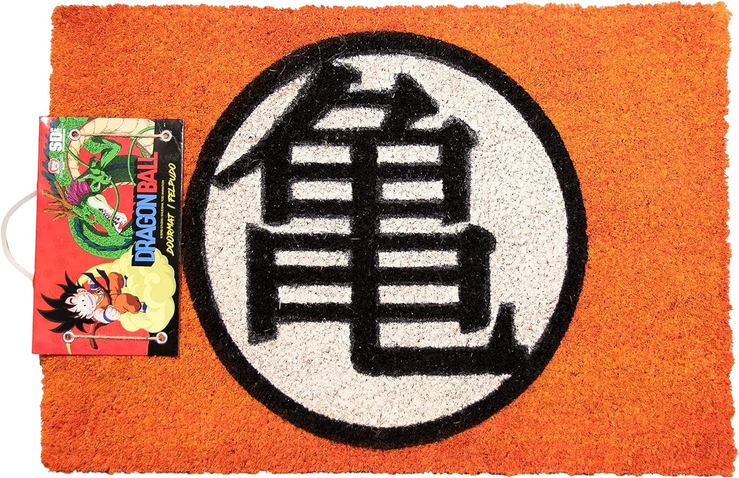 Un felpudo naranja con el símbolo negro de Kame en el centro y una etiqueta de Dragon Ball a la izquierda.