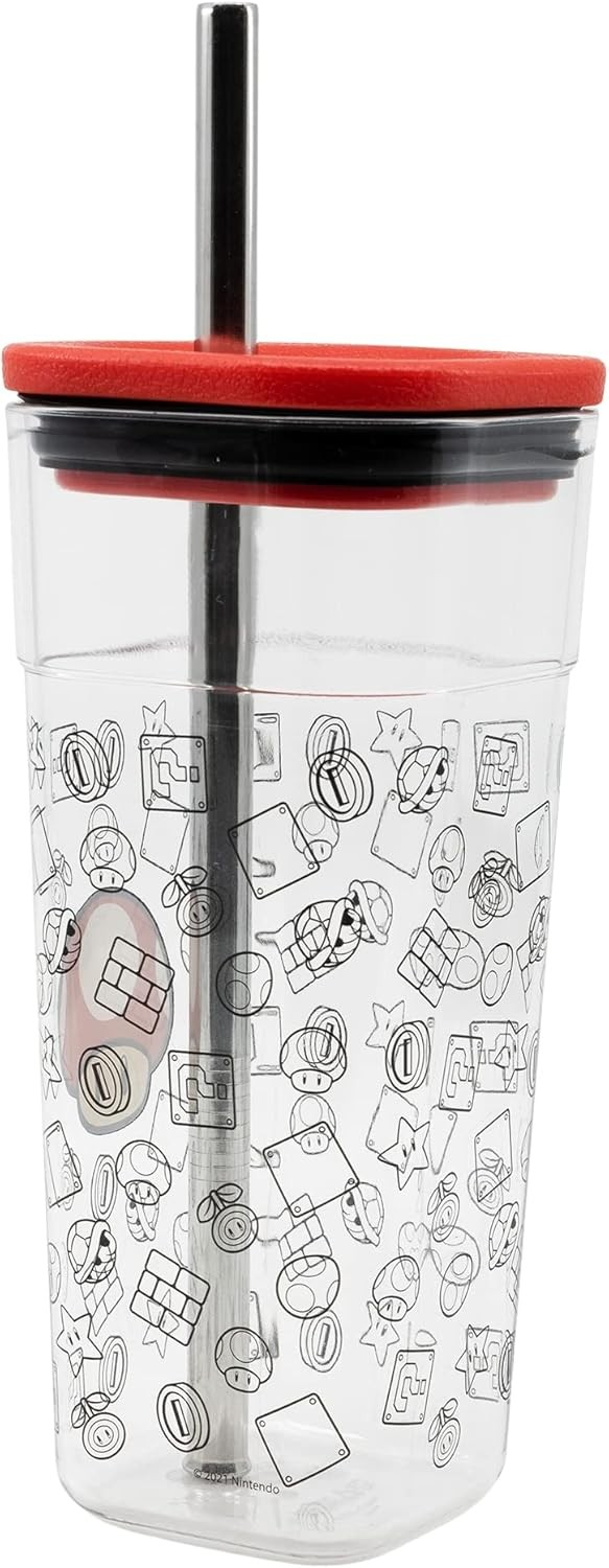 Un vaso de plástico transparente con dibujos de Super Mario, una tapa roja y una pajita de metal.