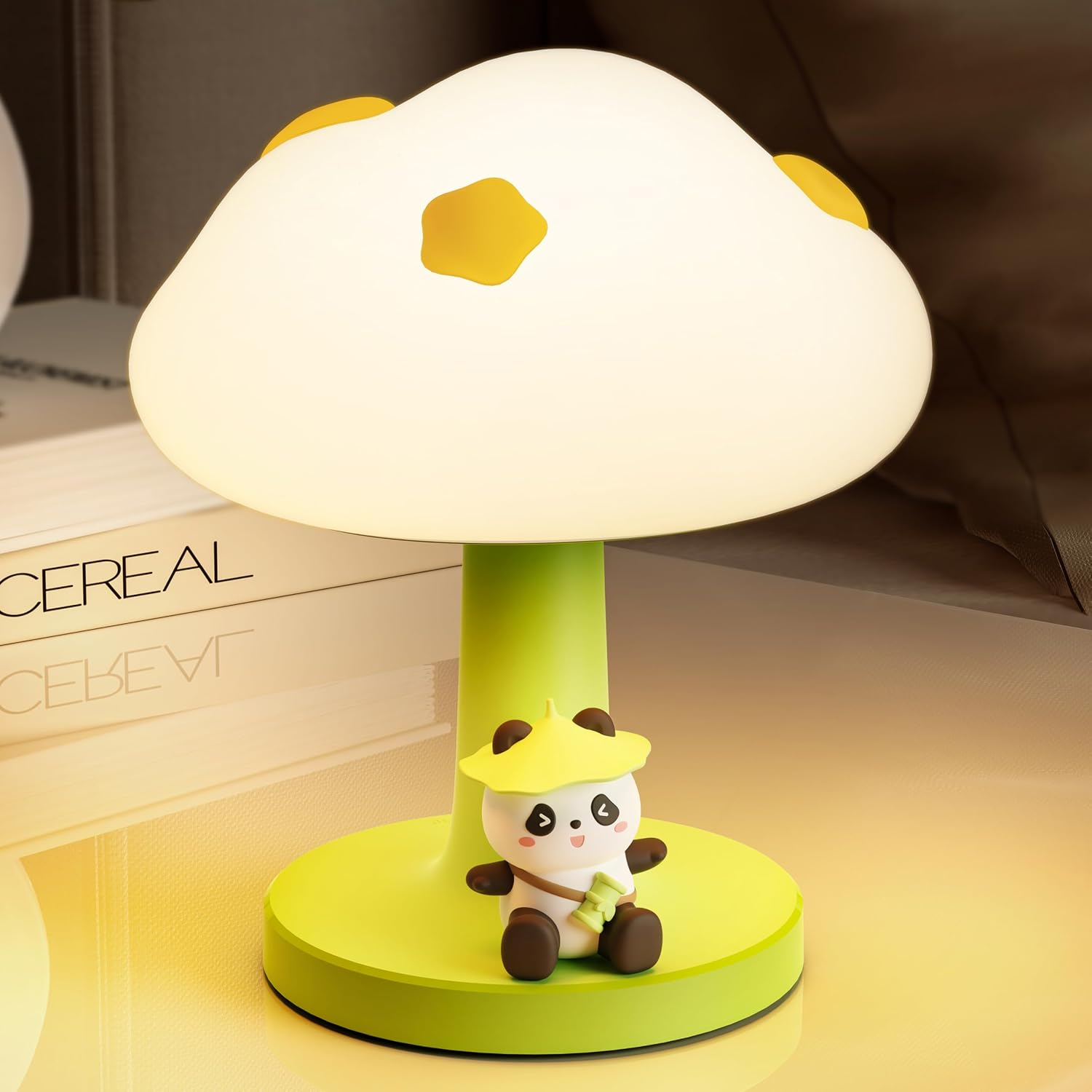 Eine süße pilzförmige Lampe in Grün und Weiß mit einer kleinen Panda-Figur auf dem Sockel, auf einem Tisch.