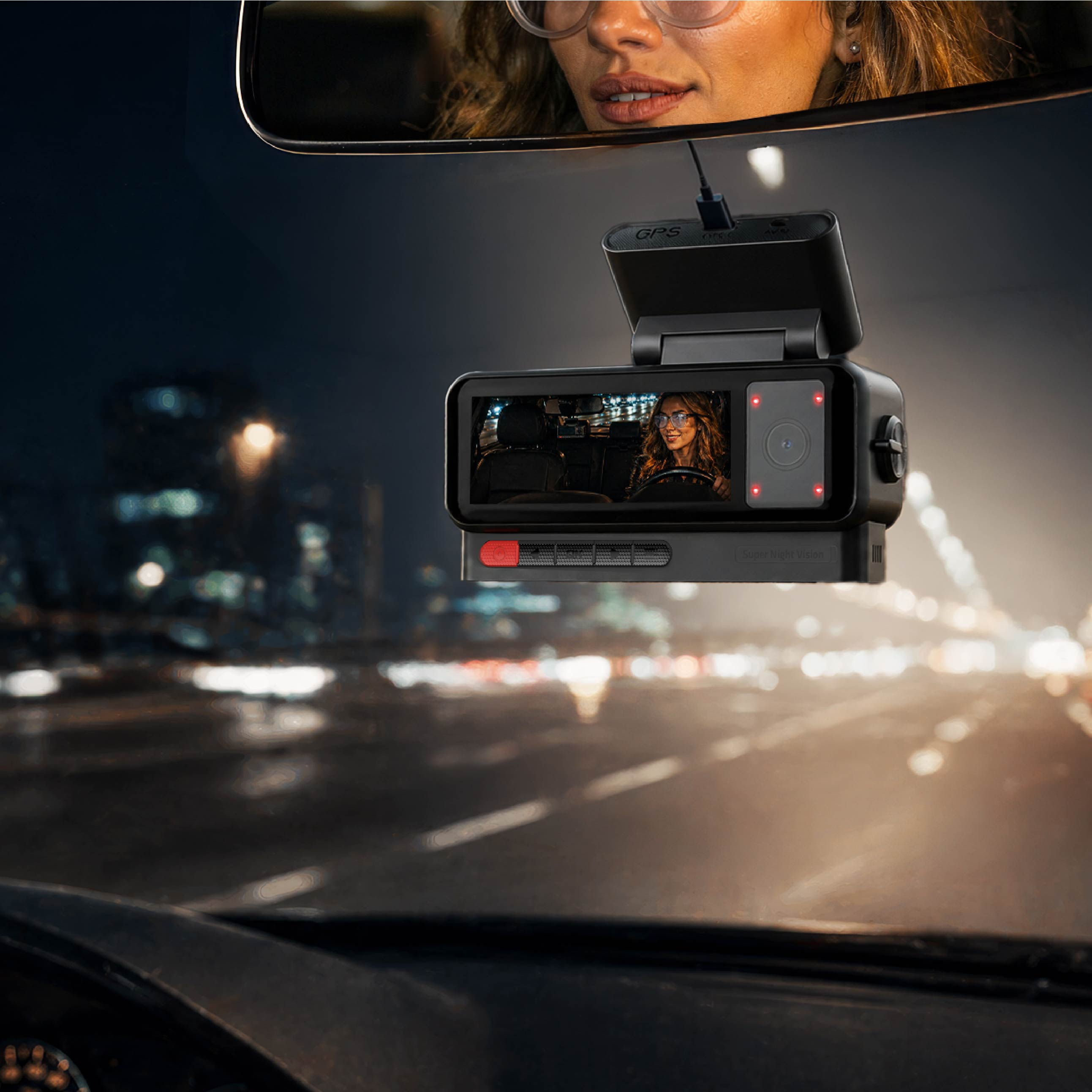 Eine Dashcam ist an einer Windschutzscheibe montiert, während eine Fahrerin nachts auf einer beleuchteten Straße fährt.