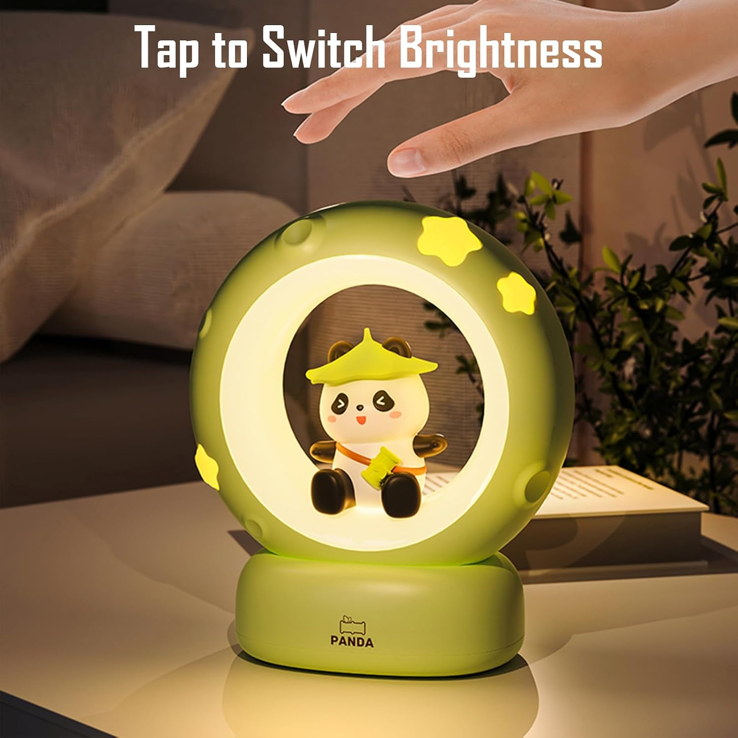 Hand berührt eine grüne kreisförmige Panda-Nachtlampe mit gelben Sternen.
