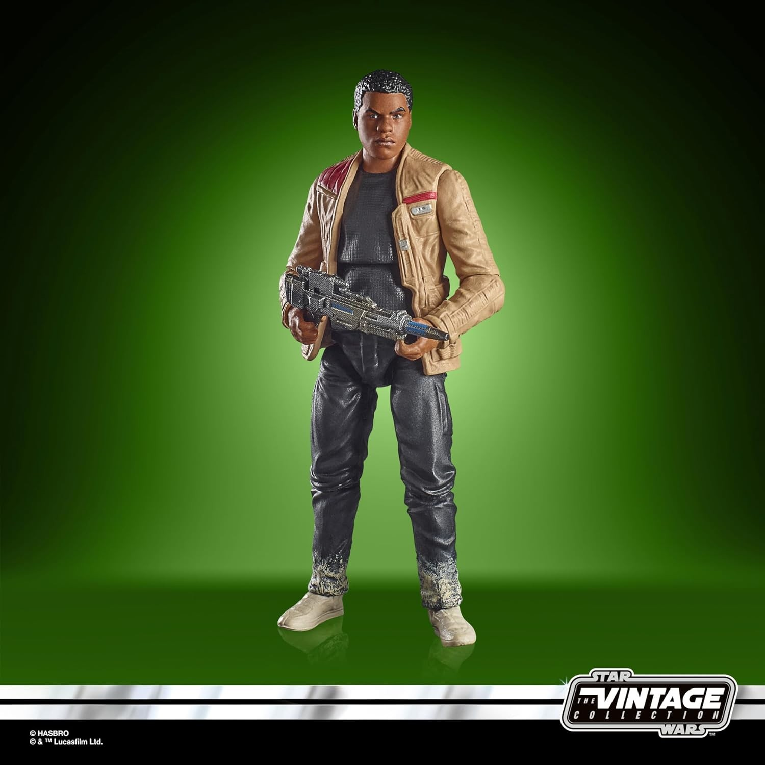 Figura de acción de Finn de Star Wars con chaqueta beige y un bláster, sobre fondo verde.