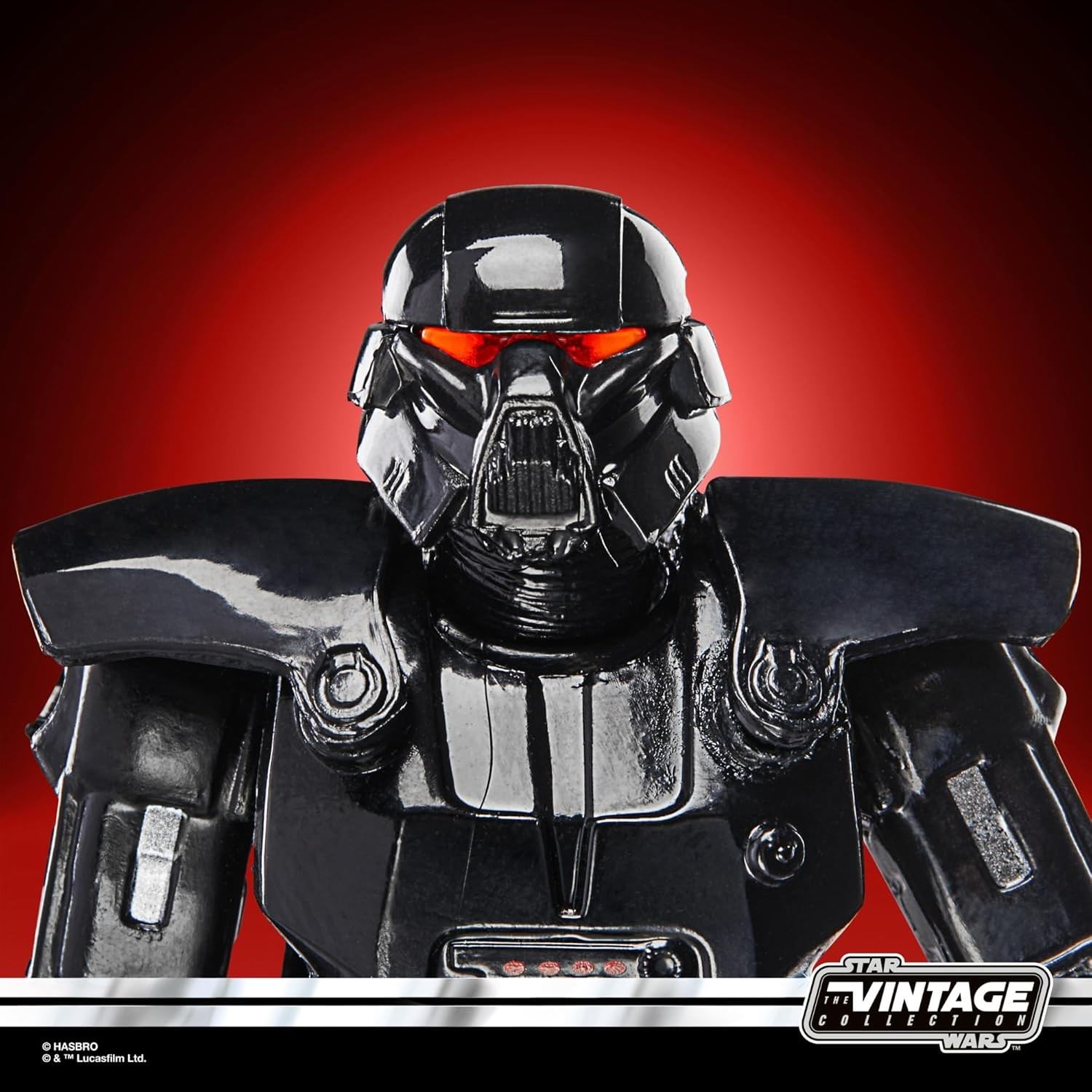 Close-up einer schwarzen Star Wars Actionfigur in Rüstung mit roten Augen vor rotem Hintergrund.