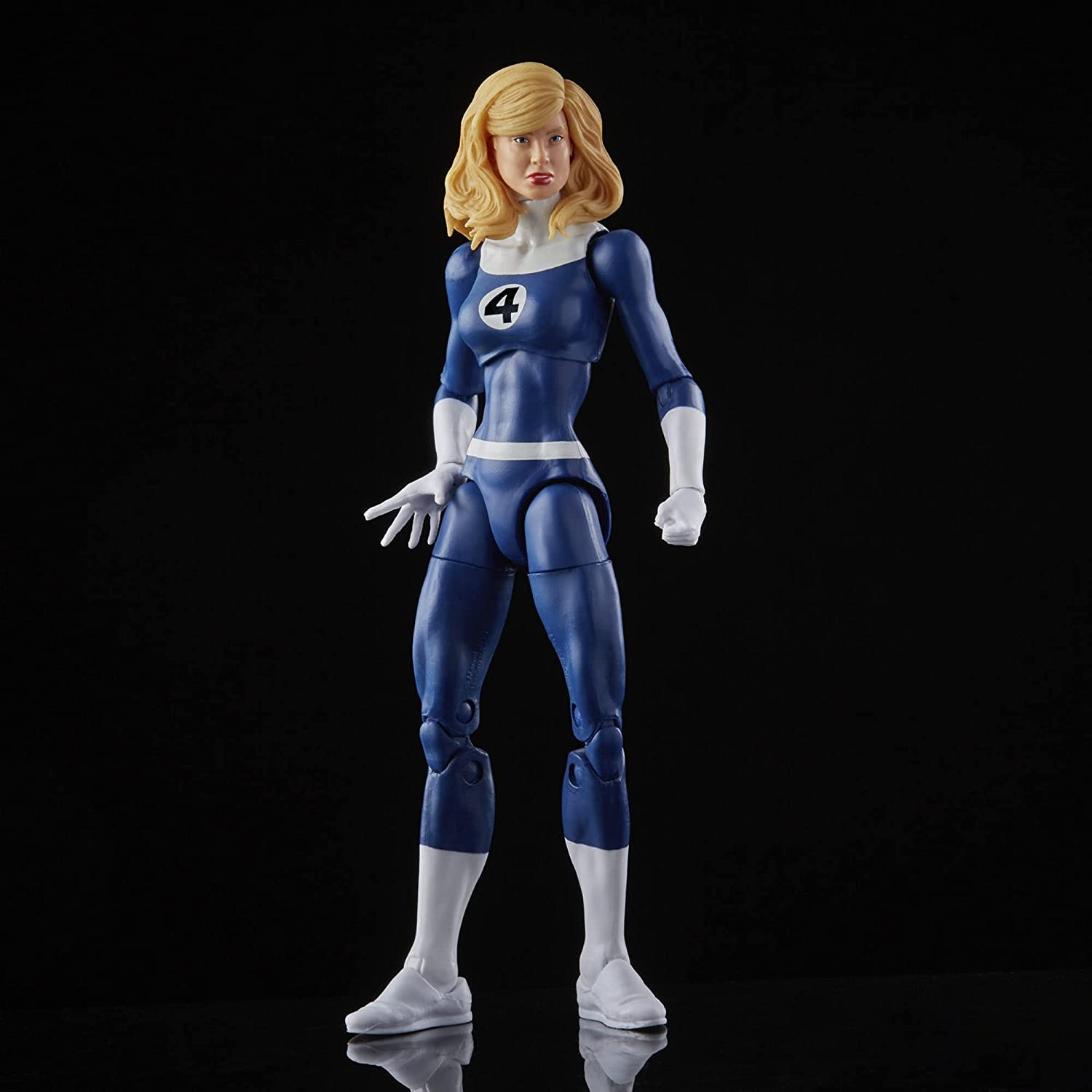 Una figura de acción rubia con traje azul y blanco de los Cuatro Fantásticos sobre fondo negro.
