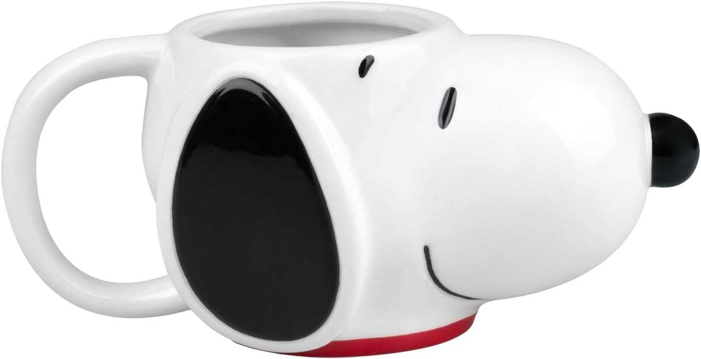 Una taza de cerámica blanca con forma de Snoopy, con orejas, ojos y nariz negros.