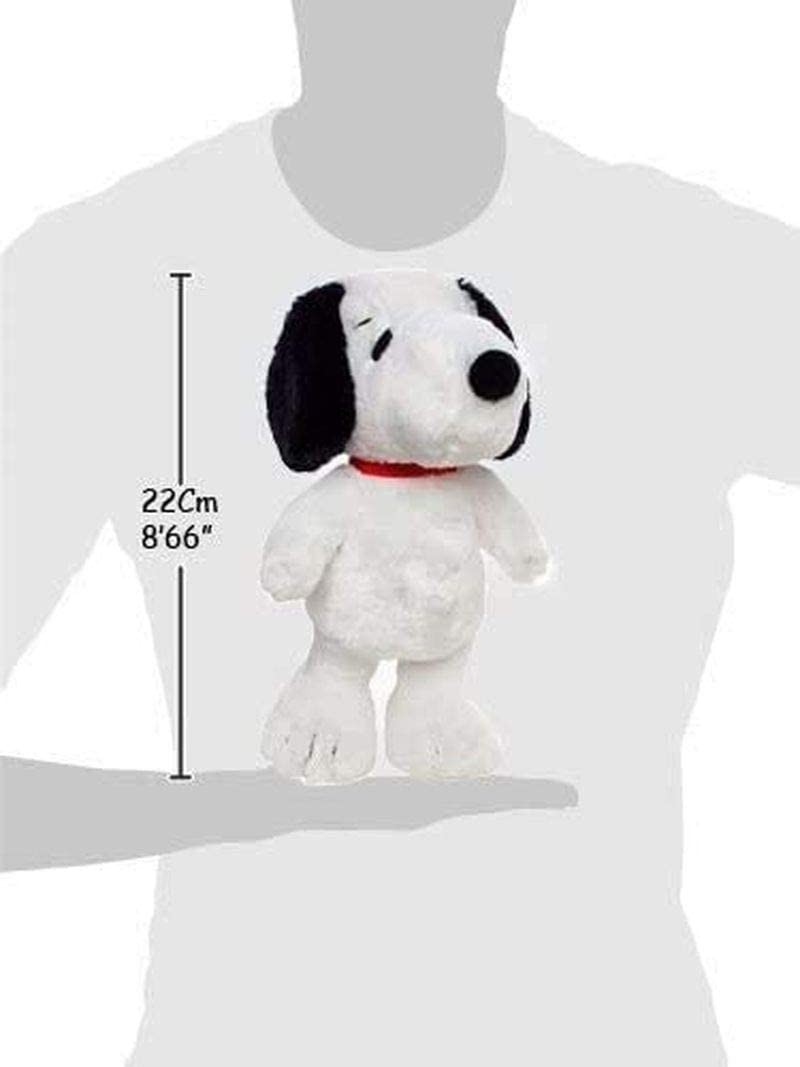 Un peluche de Snoopy de 22 cm con collar rojo, de pie frente a una silueta humana.