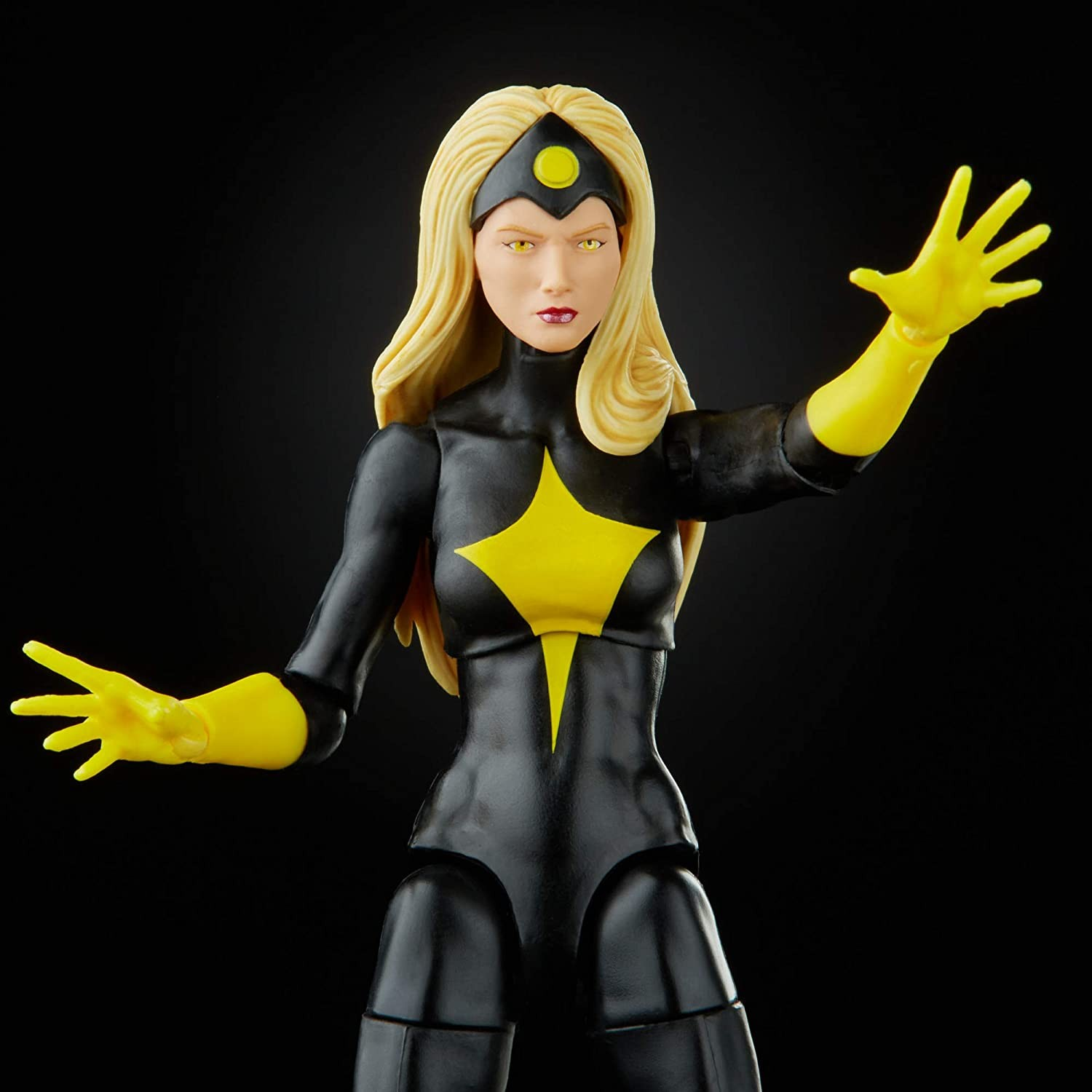 Figura de acción de una superheroína rubia con traje negro y amarillo y manos extendidas.