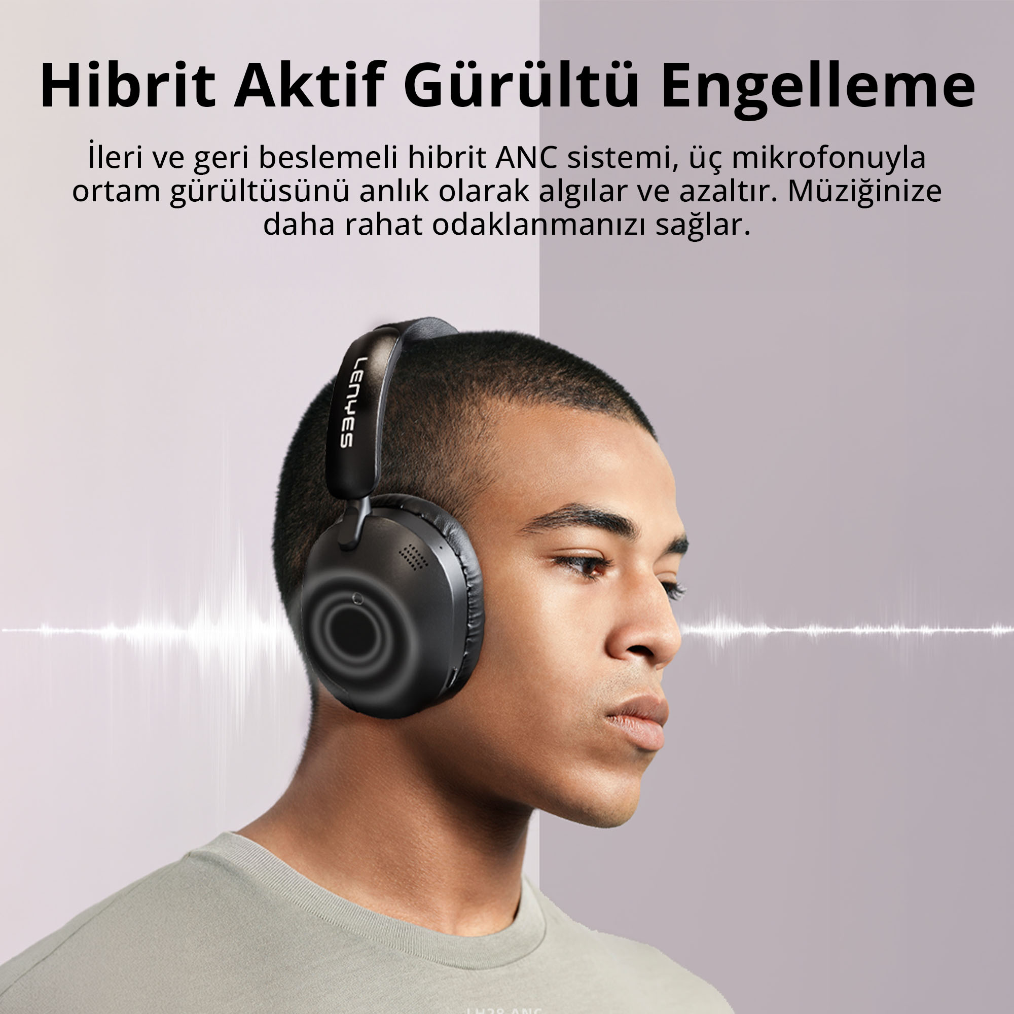 Açık renkli arka plan önünde siyah aktif gürültü önleyici kulaklık takan genç bir adam.