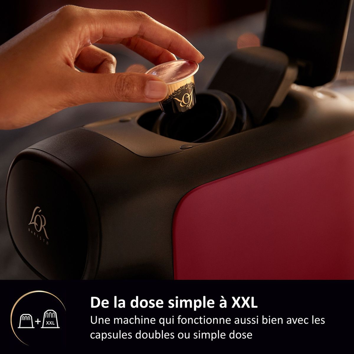 Eine Hand legt eine Kaffeekapsel in eine schwarz-rote L'OR Barista Kaffeemaschine.