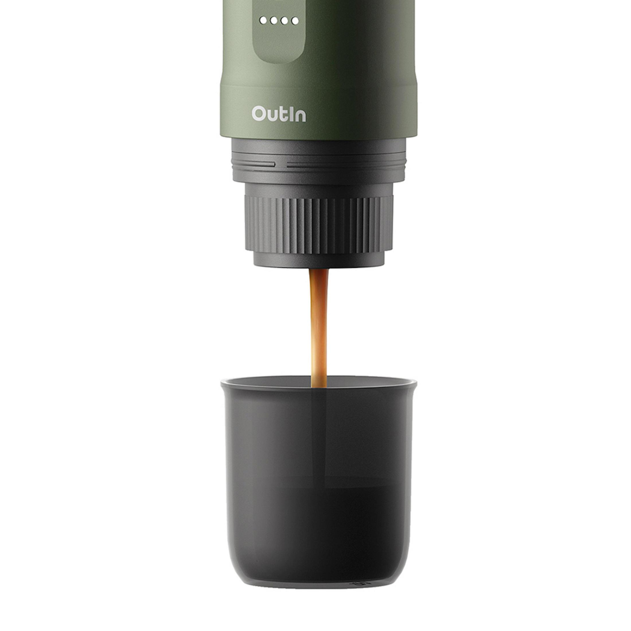 Een groene OutIn-espressomachine schenkt koffie in een klein zwart kopje tegen een witte achtergrond.
