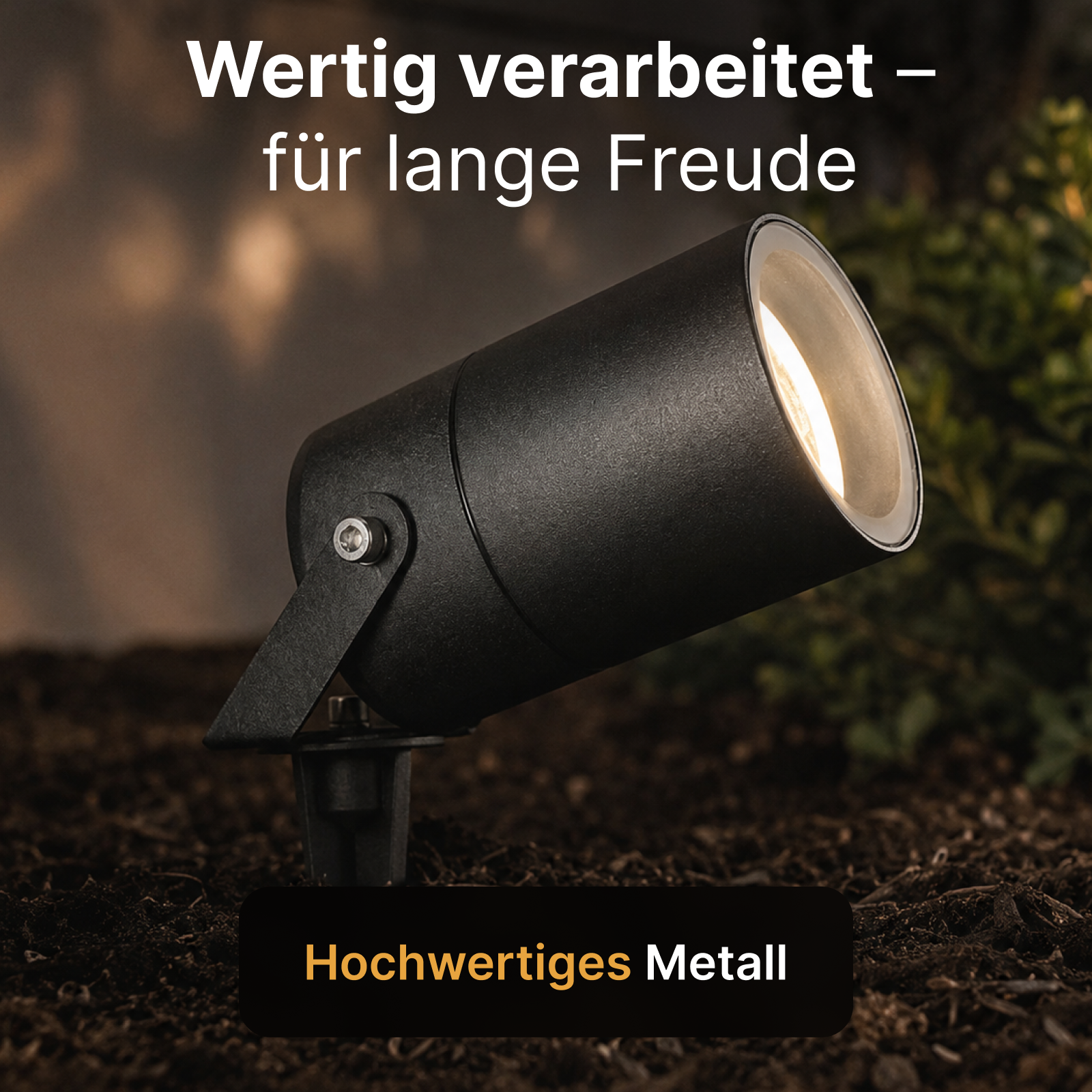 Ein schwarzer, beleuchteter LED-Gartenstrahler steckt im Boden, umgeben von dunkler Erde und grünen Pflanzen.