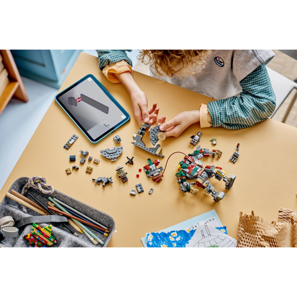 Dziecko buduje z klocków Lego na żółtym stole, instrukcje są widoczne na tablecie.