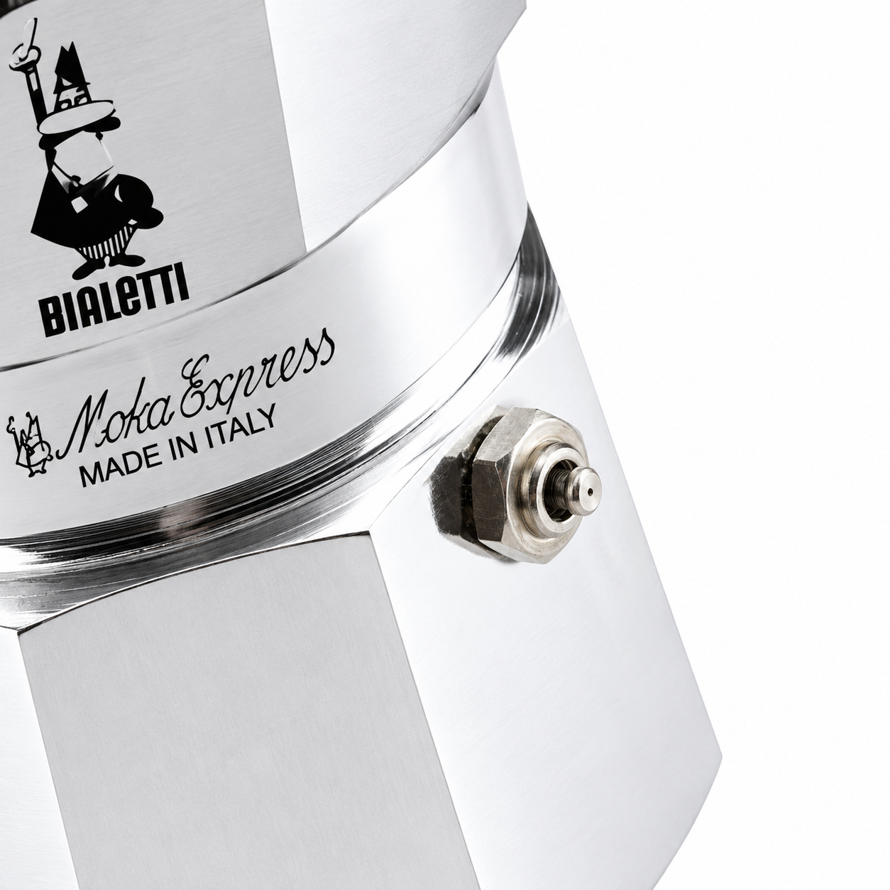 Primo piano di una caffettiera argentata Bialetti Moka Express con logo e valvola di sicurezza su sfondo bianco.