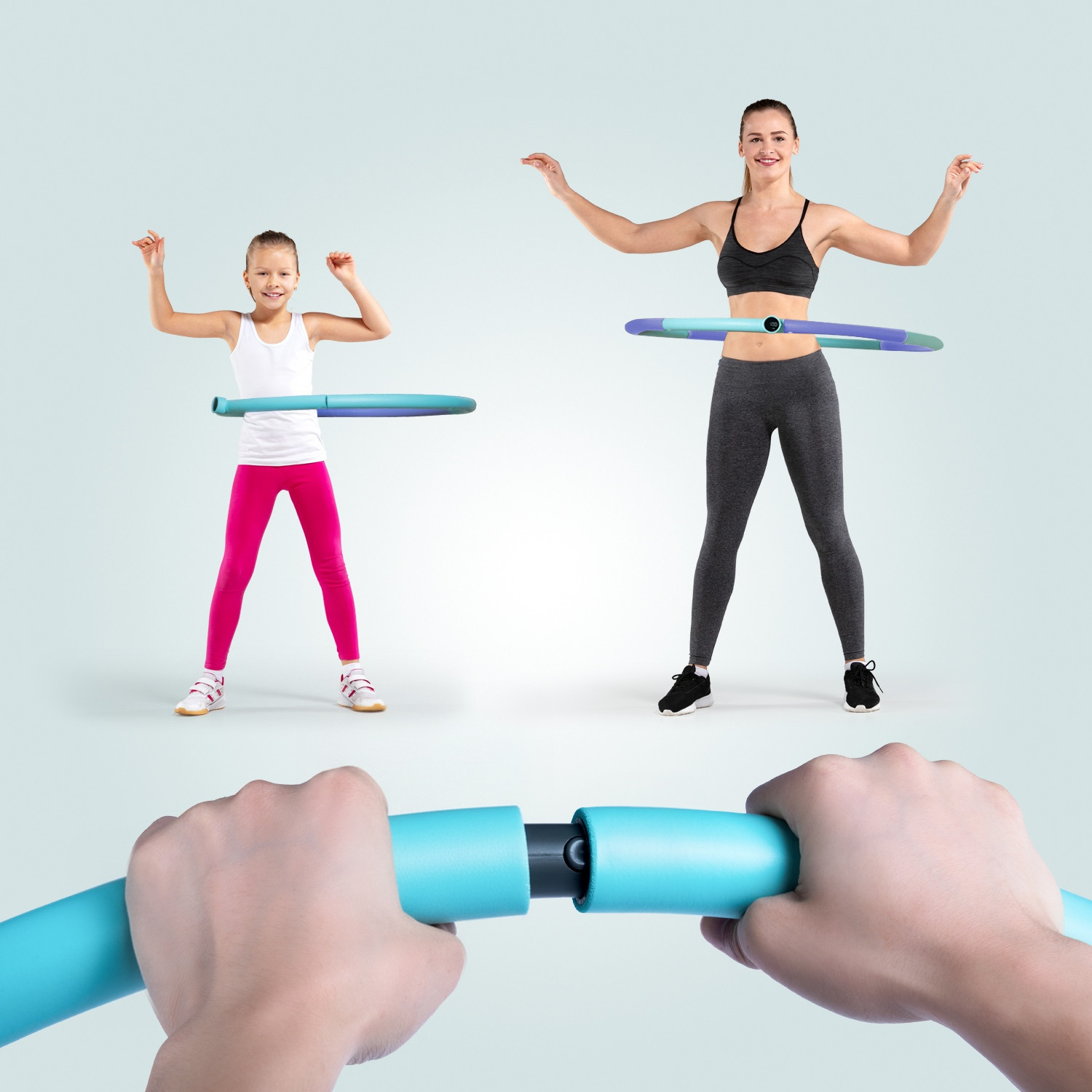 Eine Frau und ein Mädchen hula-hoopen, während Hände im Vordergrund einen blauen Hula-Hoop-Reifen halten.