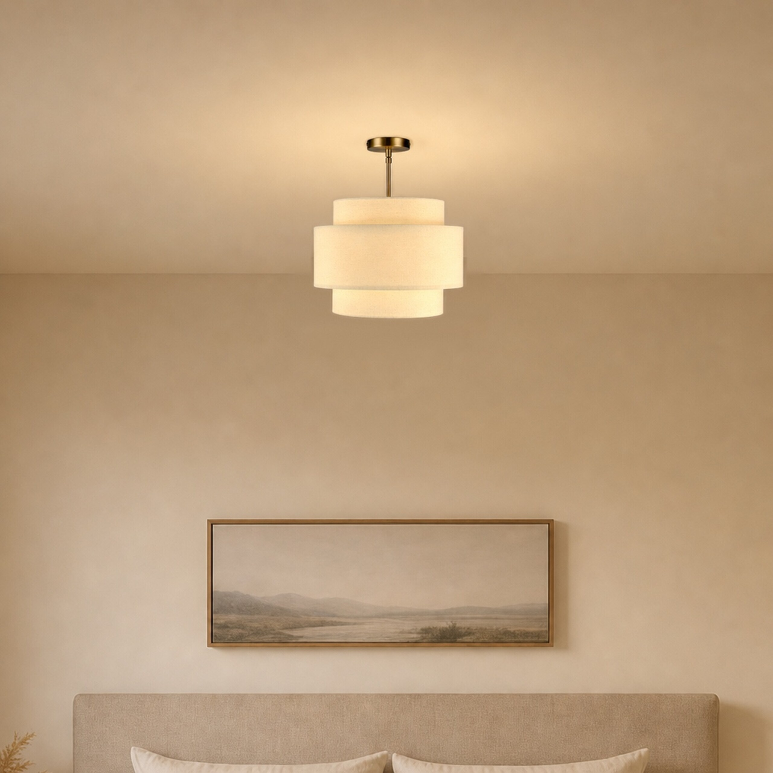 Eine dreistufige Hängeleuchte erhellt eine beige Wand über einem Bett und einem gerahmten Landschaftsbild.