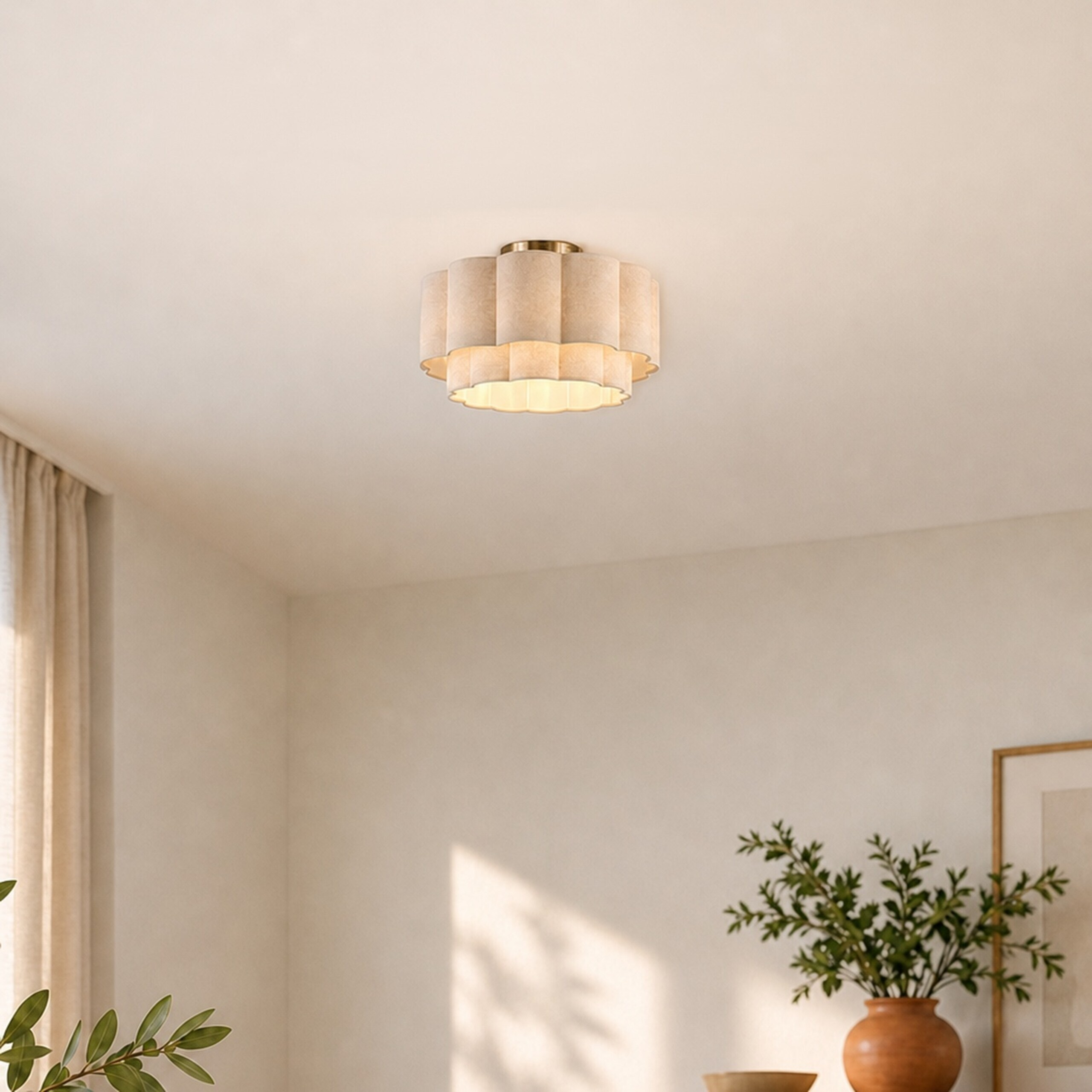 Eine beige plissierte Deckenlampe an einer weißen Decke in einem hellen Raum mit Pflanzen und Vase.