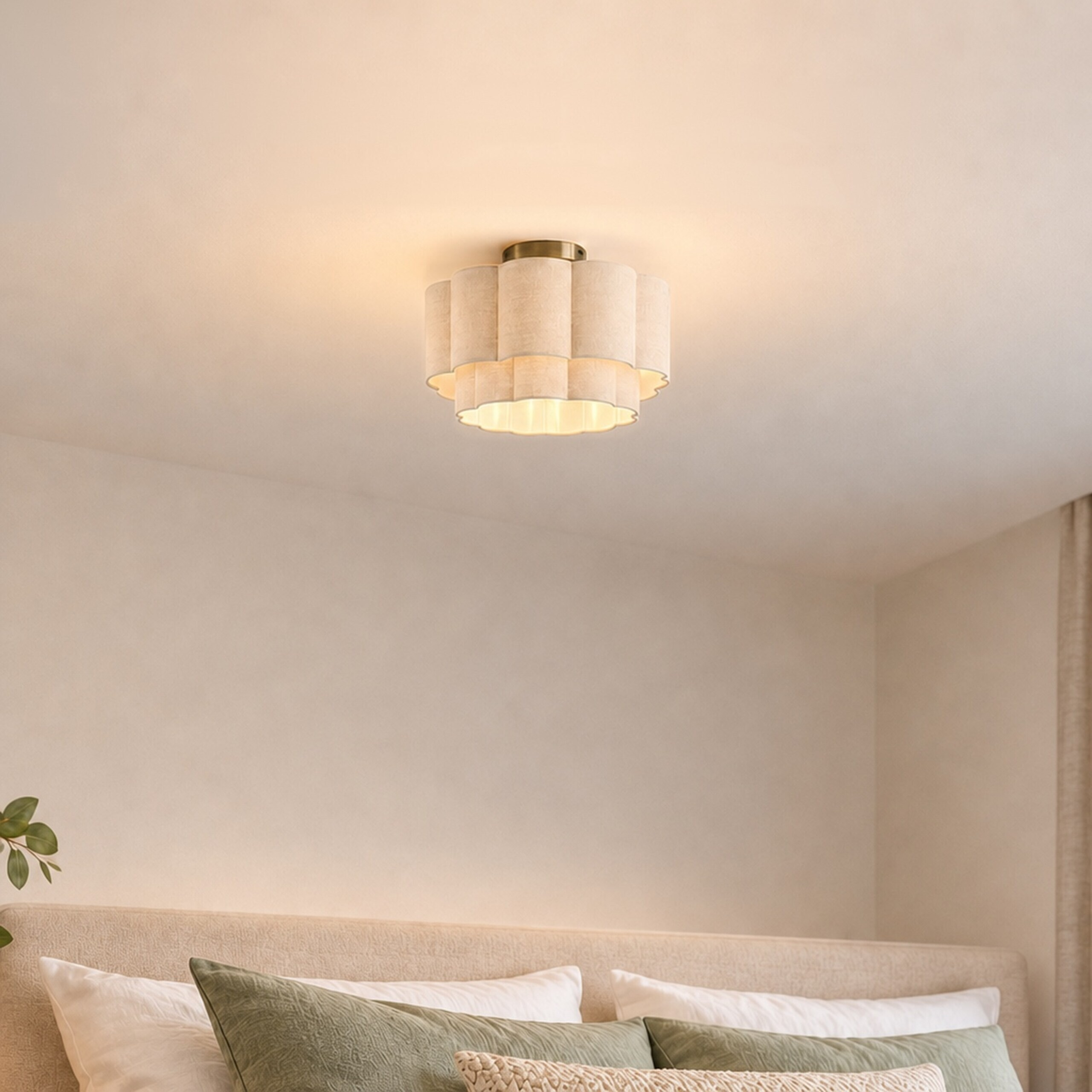Eine elegante Deckenlampe mit beigen Schichten beleuchtet ein ruhiges Schlafzimmer mit Kissen.