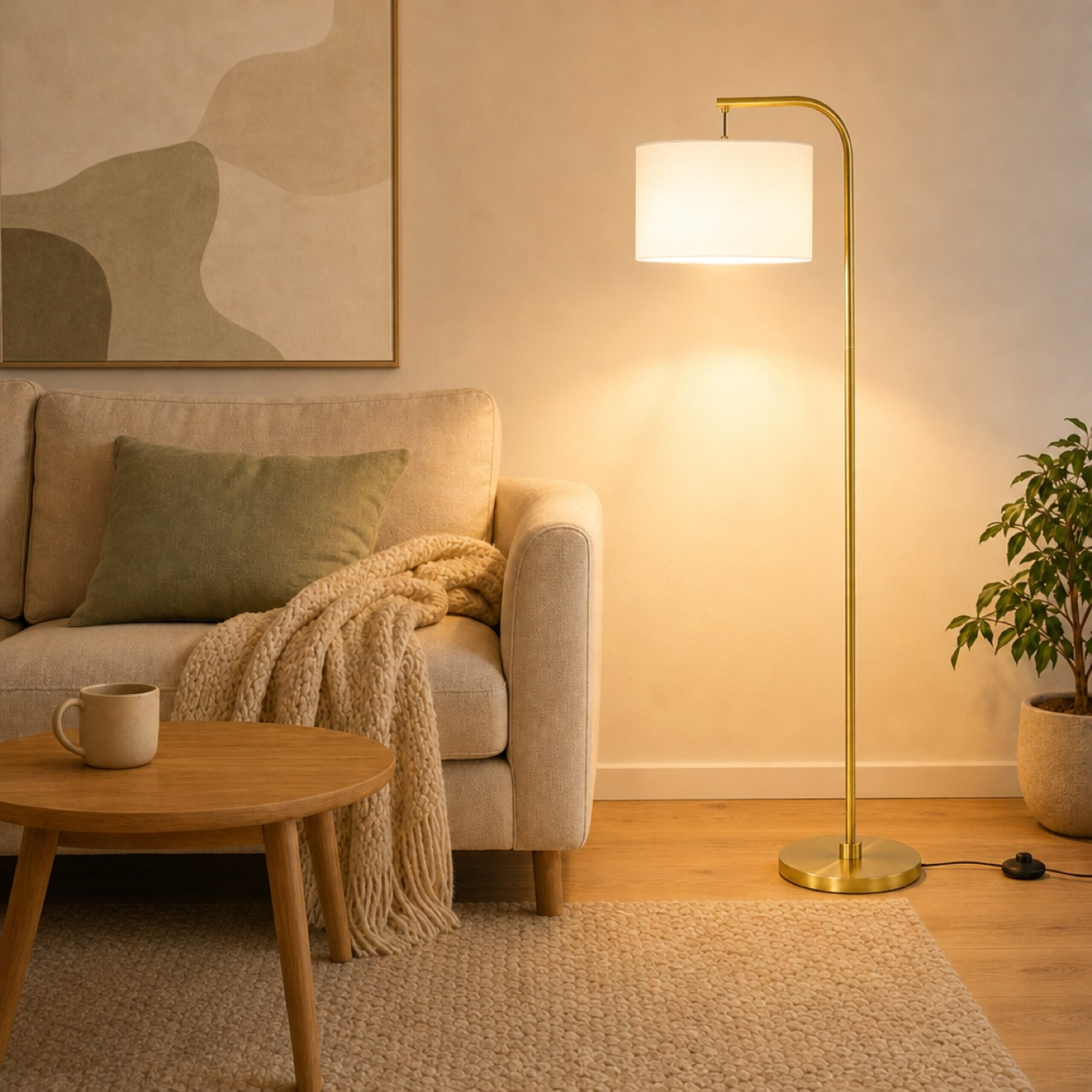 Gemütliches Wohnzimmer mit hellem Sofa, goldener Stehlampe, Holztisch mit Tasse, Kissen und Pflanze vor neutraler Wand.