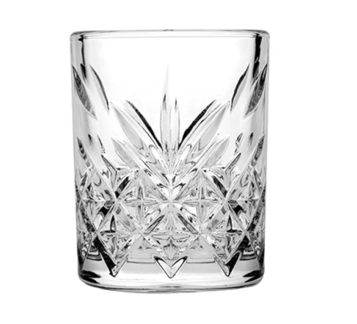 Beyaz arka planda dekoratif elmas ve yıldız desenlerine sahip berrak kristal bir bardak.