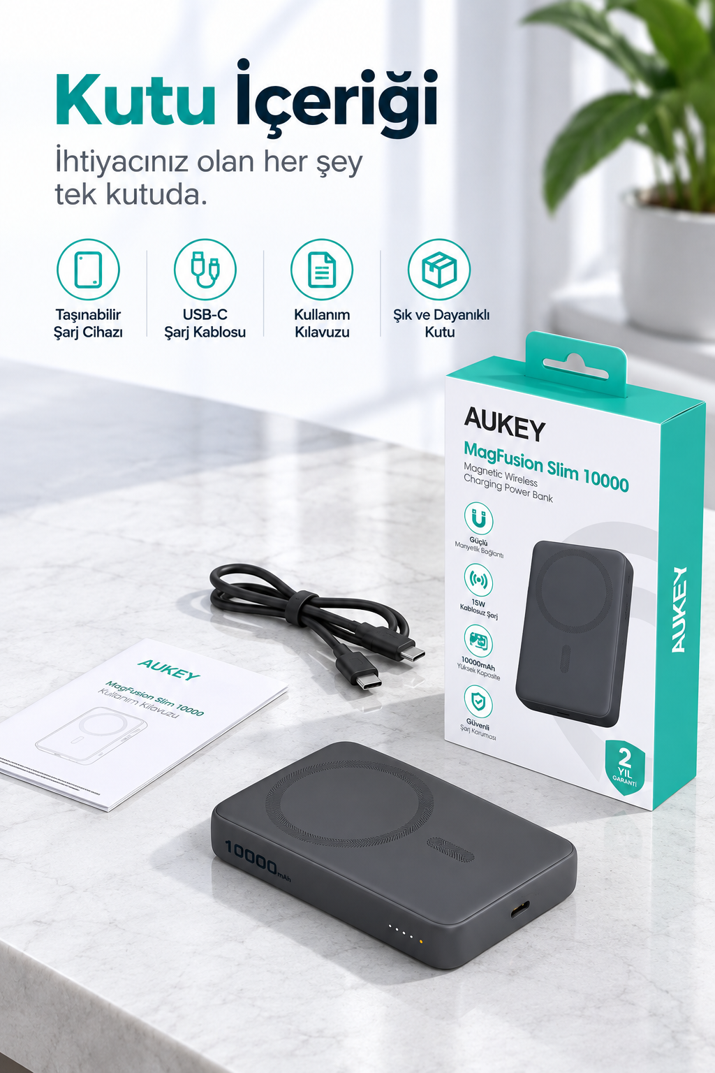 Mermer yüzeyde kutusuyla birlikte Aukey MagFusion powerbank, USB-C kablo ve kılavuz.