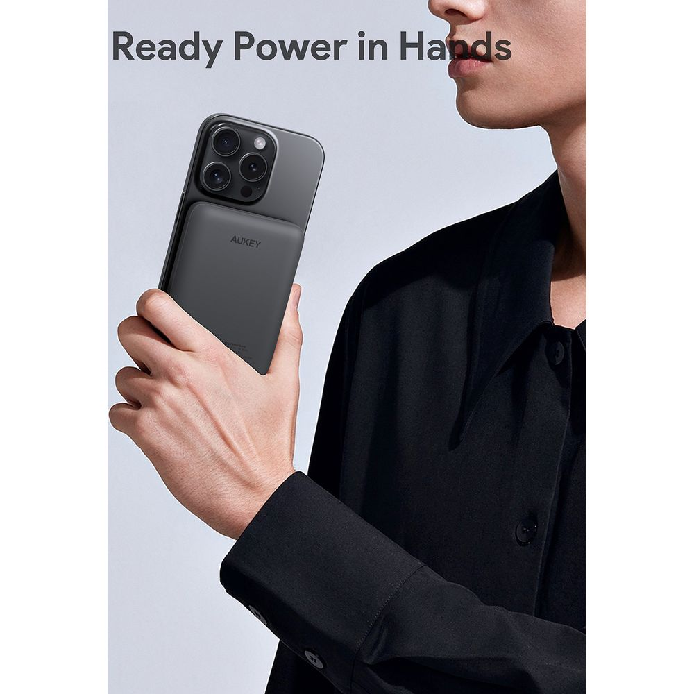 Aukey taşınmaz şarj cihazı takılı siyah akıllı telefonu tutan kişi, metin Ready Power in Hands.